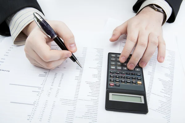 Businessman holding a pen and counts the budget — Stock Photo, Image