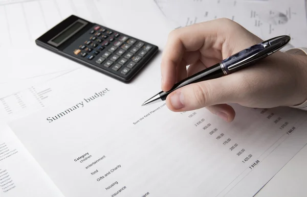 Geschäftsmann hält Stift in der Hand und zählt das Budget — Stockfoto