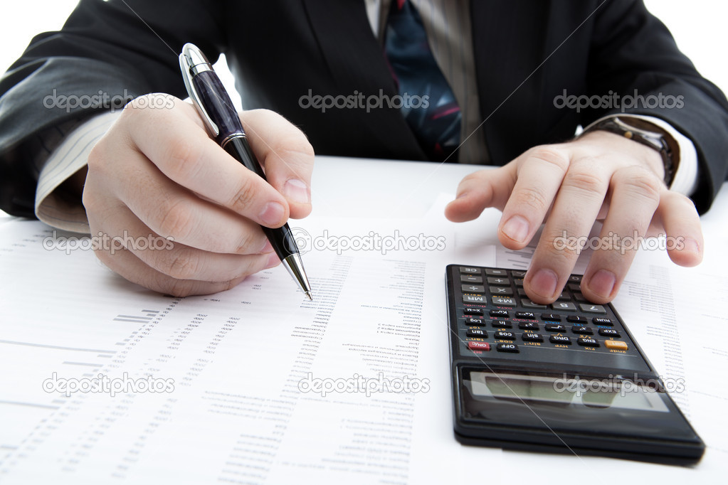 businessman holding a pen and counts the budget