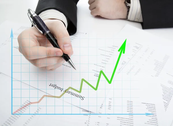 Empresário segurando uma caneta e conta o orçamento e diagrama — Fotografia de Stock