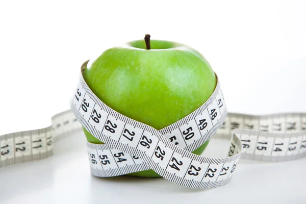 Green apple with a ruler Stock Photo