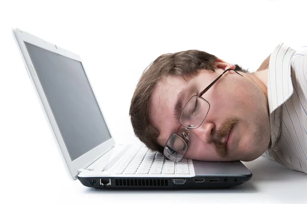 Mann som sover på et tastatur på arbeidsplassen – stockfoto