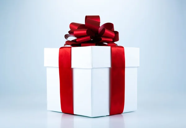 Белая подарочная коробка с красной лентой и луком — стоковое фото