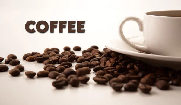 Xícara de café preto com grãos de café torrados com título de café — Fotografia de Stock