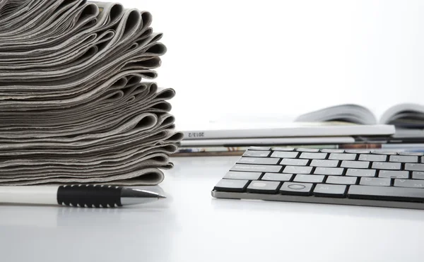 Stack of newspapers and keyboard — Stock Photo, Image