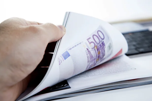 The hand through the pages of the magazine with currency note — Stock Photo, Image
