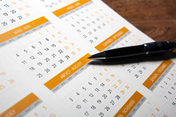 Calendário de parede com caneta closeup — Fotografia de Stock