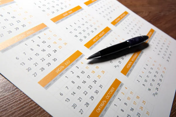 Calendário de parede com caneta closeup — Fotografia de Stock