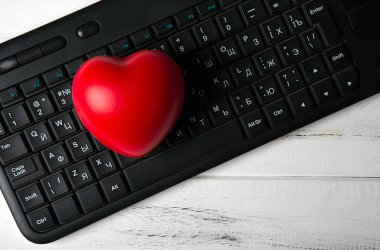 Not defteri web sitesi üst görünümündeki siyah pc klavyesinde kırmızı kalp