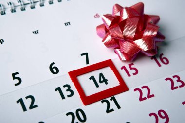 wall calendar with day 14 february and  festive bow 