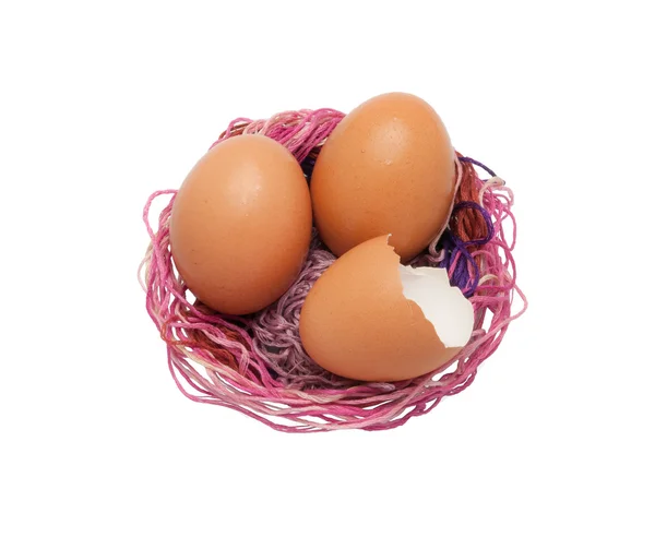 Vejce a vaječné skořápky v růžové bavlněné hnízdo — Stock fotografie