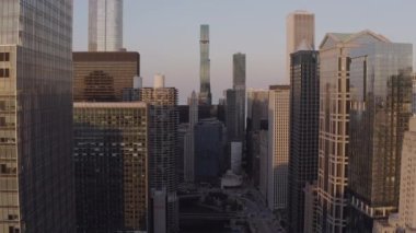 Chicago Nehri üzerinde Chicago şehir merkezindeki binaların arasında uçuyor.