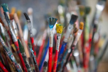 Kovada bir sürü kirli boya fırçası var. Farklı sanatçı fırçaları, yakın çekim görüntüsü