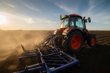 Traktör tarlada çalışıyor, tarlayı ekime hazırlıyor, tarlayı sürüyor.