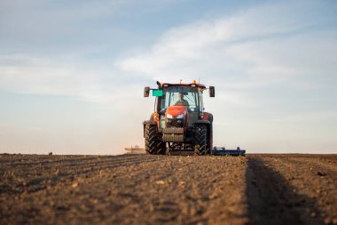 Traktör tarlada çalışıyor, tarlayı ekime hazırlıyor, tarlayı sürüyor.