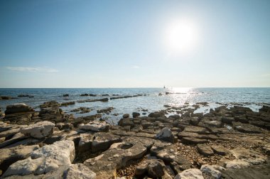 Istrian yarımadasının kıyısında. Hırvatistan 'da deniz ve kayalar. Adriyatik Denizi kıyısında gün batımında. Sahilde taş plajı