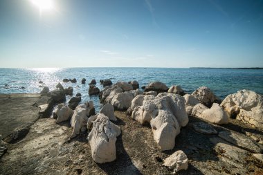 Istrian yarımadasının kıyısında. Hırvatistan 'da deniz ve kayalar. Adriyatik Denizi kıyısında gün batımında. Sahilde taş plajı