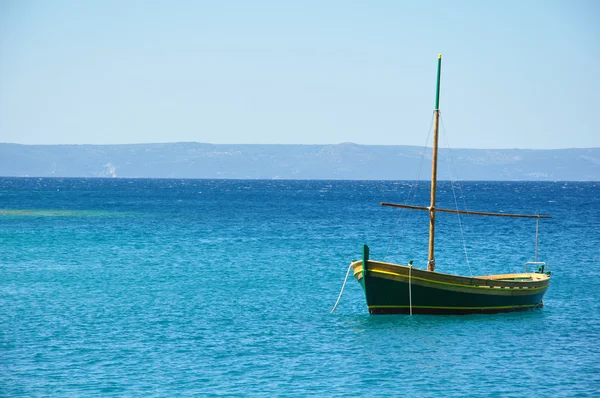 Barco verde en el mar azul Fotos de stock libres de derechos