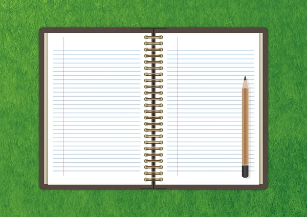 Откройте ноутбук с белой страницей и карандашом на зеленой траве backgrou — стоковое фото