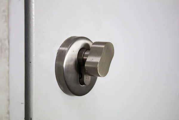 Detalhe de um botão metálico na porta branca horizontal — Fotografia de Stock
