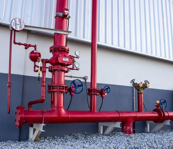 Rör och ventiler med röda knoppar för varmvatten — Stockfoto