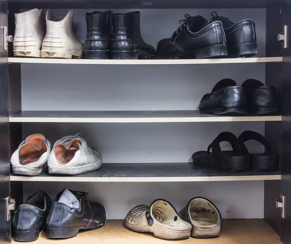 Schoenen, gymnastiekschoenen, laarzen en ander schoeisel op een rek — Stockfoto