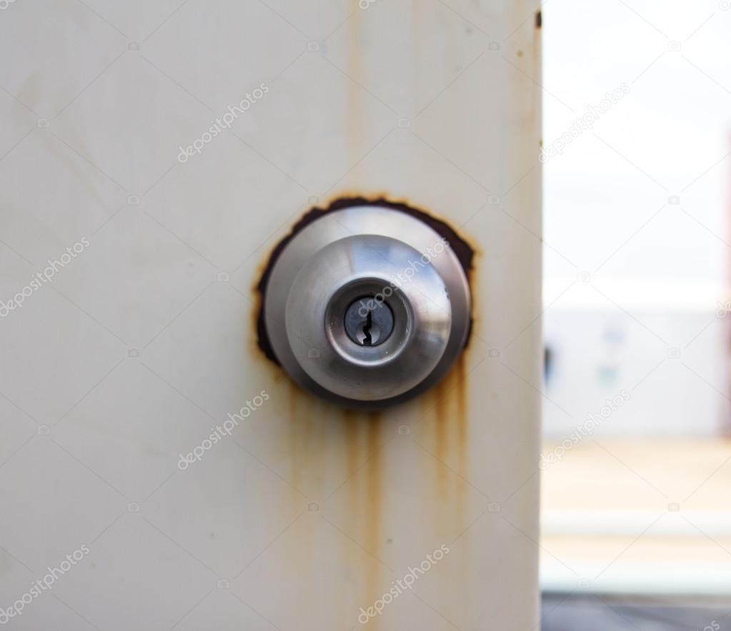 Silver door handle on white old door background 