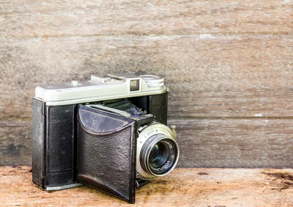 Old retro camera on vintage wooden boards abstract background — Stock Photo, Image