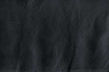 Black bright macro photo of texture of the genuine faux vegan leather. Fashion pattern and background. Leather with embossing.