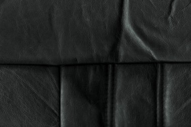 Black bright macro photo of texture of the genuine faux vegan leather. Fashion pattern and background. Leather with embossing.