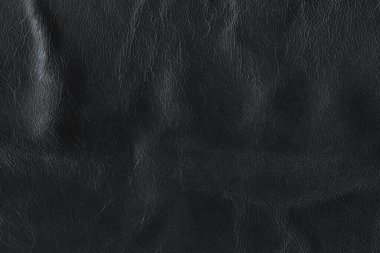 Black bright macro photo of texture of the genuine faux vegan leather. Fashion pattern and background. Leather with embossing.