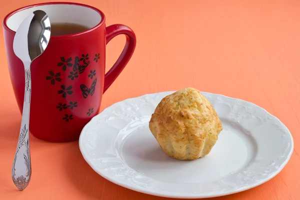 Käsemuffin und eine Tasse Tee — Stockfoto