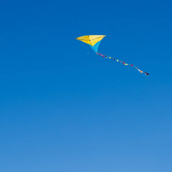 Colorful kite against the blue sky — Stock Photo, Image