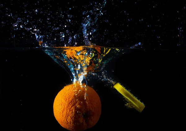 在水中抛出的多汁橙 免版税图库图片