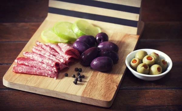 Slices of salami and black and green olives — Stock Photo, Image