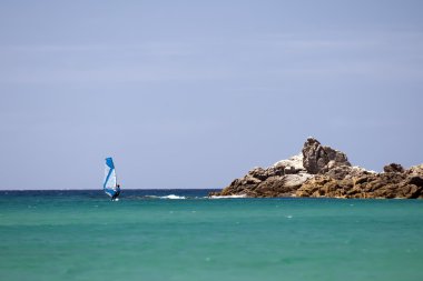 A windsurf in the tourquoise blue sea in Sardinia Italy clipart