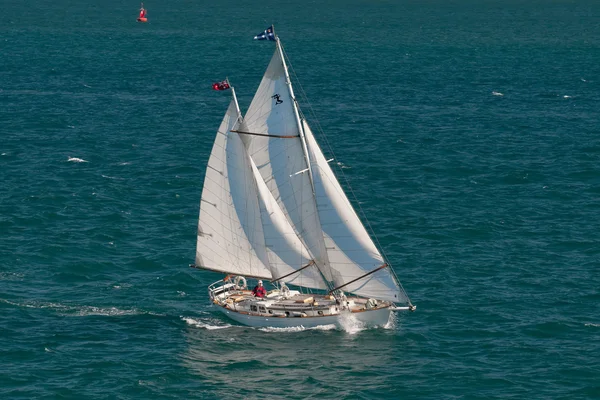En båt med ensliga kapten segling i det blå havet — Stockfoto
