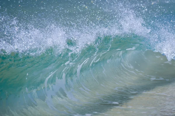 Una ola rompiendo en la orilla de la arena —  Fotos de Stock