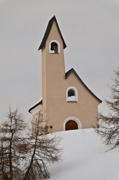 Uma pequena igreja de montanha no fundo da neve tempo de inverno — Fotografia de Stock