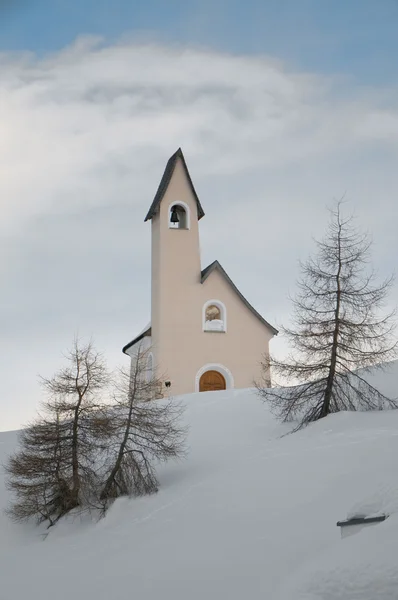 Eine kleine Bergkirche im schneebedeckten Hintergrund — Stockfoto