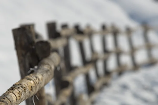 Una cerca de madera sobre fondo de nieve blanca en invierno —  Fotos de Stock