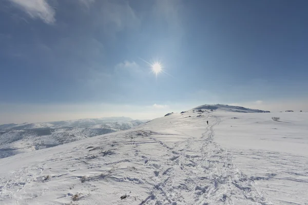 Ψηλό βουνό ηλιόλουστη θέα με απομονωμένες πεζοπόρος στο ίχνος — Φωτογραφία Αρχείου