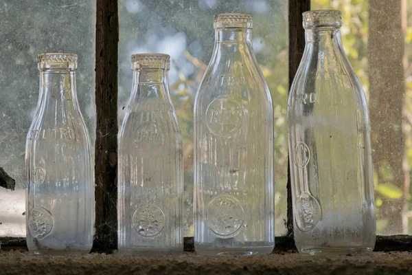 Tomma mjölkflaskor nära ett fönster — Stockfoto