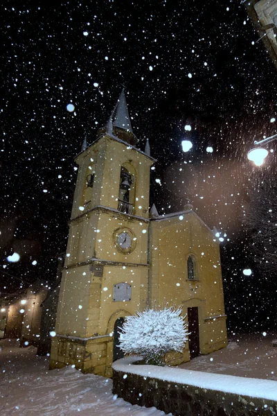 Kış geceleri kar yağışı sırasında bir kilise — Stok fotoğraf