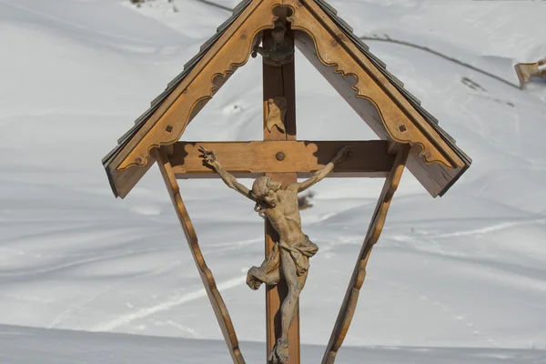 Dřevěné vyřezávané Krista v pozadí sněhu — Stock fotografie