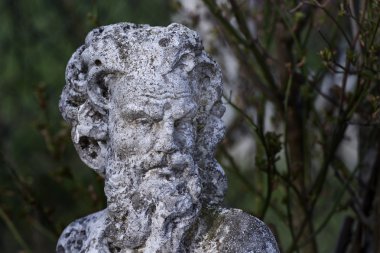 Orman arka planında eski bir heykel