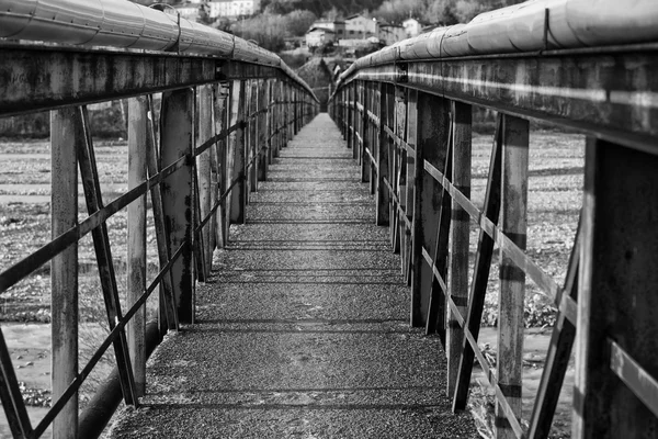 Vecchio ponte metallico su un fiume in bianco e nero — Foto Stock