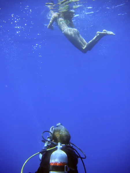 Scuba diver pryč při fotografování snorkelist pod vodou — Stock fotografie