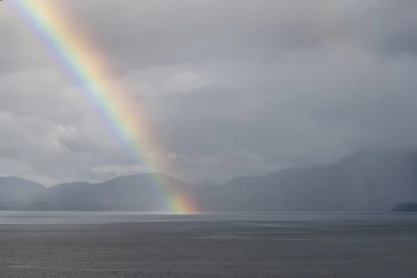 Um arco-íris descendo no mar — Fotografia de Stock