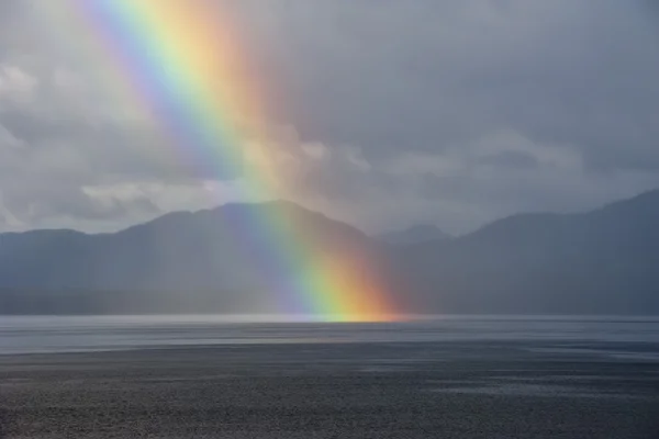 En regnbåge som går ner på havet — Stockfoto